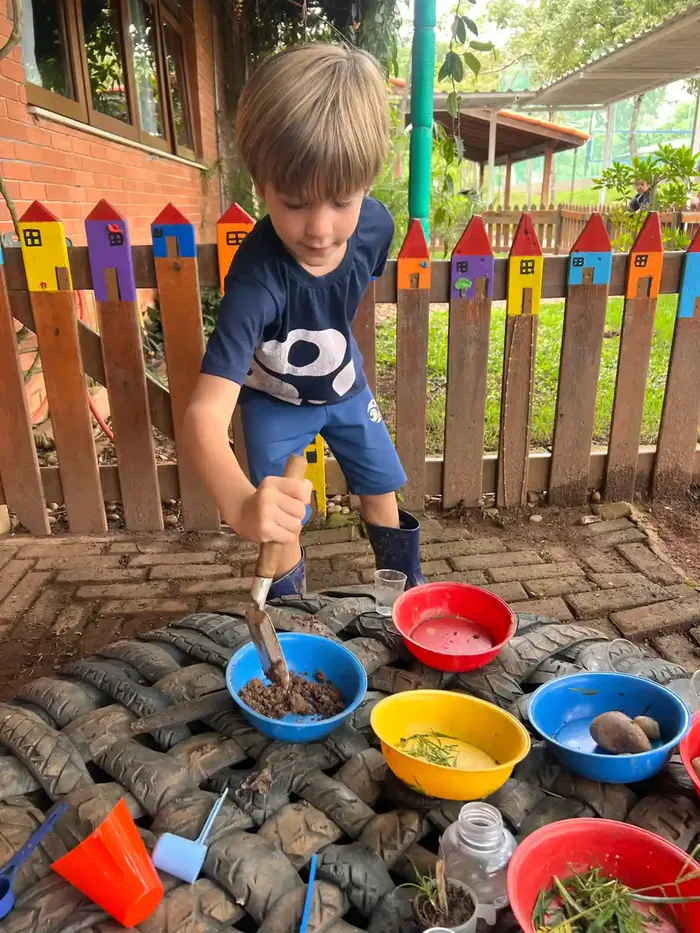 Crianças brincando no quintal, em área verde do campus
